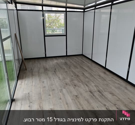 רצפת פרקט עץ בחדר עם קירות זכוכית